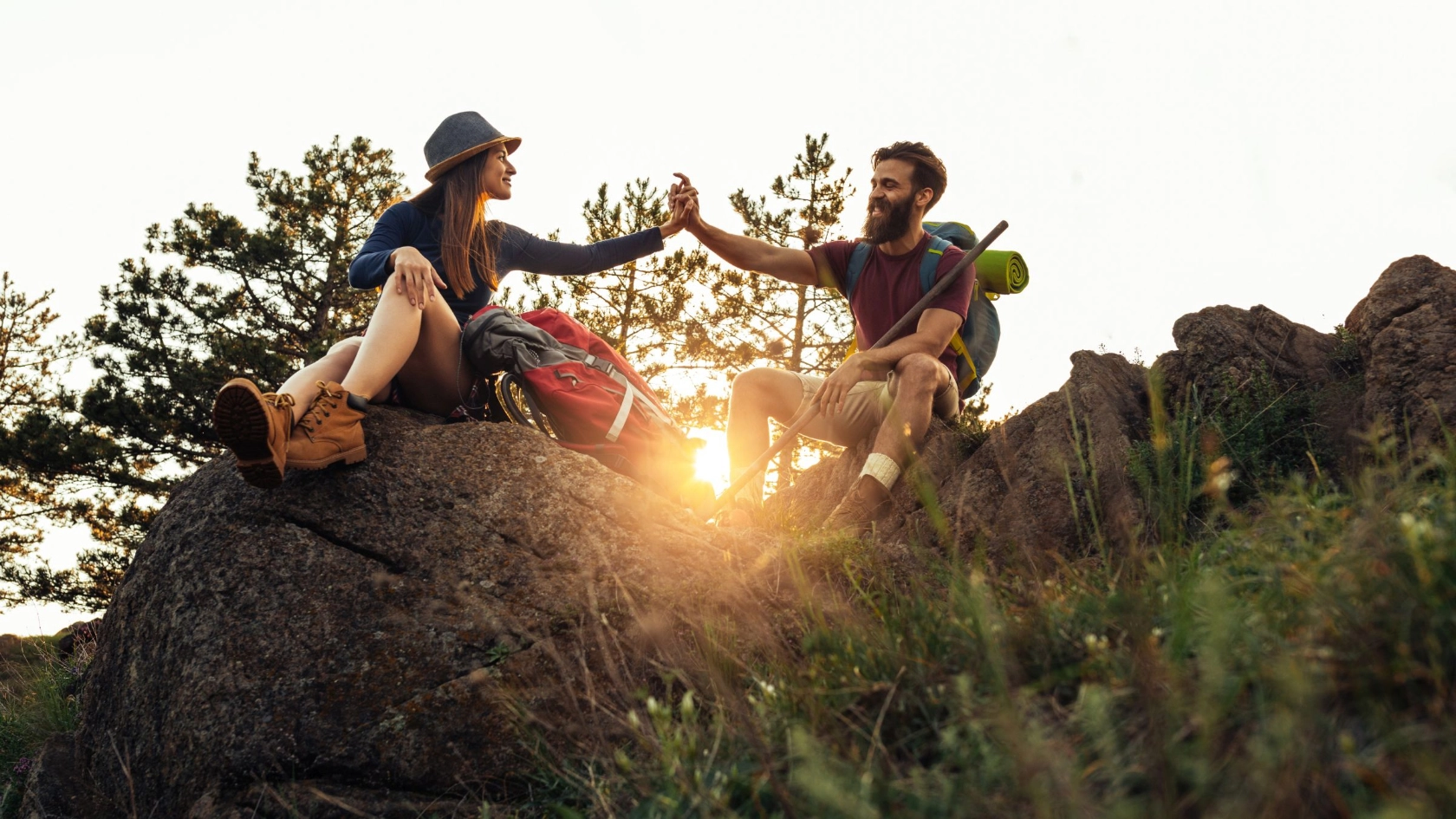 Wanderpaar sitzt vor Sonnenuntergang auf Felsgipfel